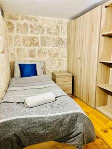 Qormi的住宿－Serenity 2，一间卧室配有一张带蓝色枕头的大床