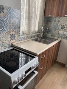 a kitchen with a sink and a stove top oven at Serenity 2 in Qormi