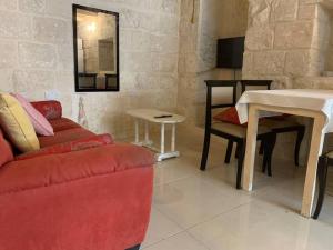 a living room with a red couch and a table at Serenity in Qormi
