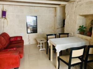 ein Wohnzimmer mit einem weißen Tisch und einem roten Sofa in der Unterkunft Serenity in Qormi
