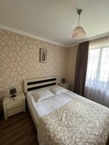 a bedroom with a white bed and a window at Crystal Kazbegi in Stepantsminda