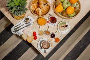 una mesa cubierta con diferentes tipos de pan y fruta en room Select Via Veneto, en Roma