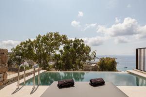 a swimming pool with a view of the ocean at Calma Suites Mykonos in Psarou