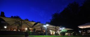 zwei Sonnenschirme vor einem Restaurant in der Nacht in der Unterkunft Waldhotel Riesebusch in Bad Schwartau