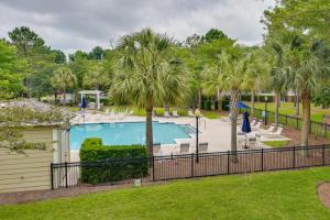 uma piscina com palmeiras e uma cerca em Mount Pleasant Condo with Pool and Bikes Near Beach! em Charleston