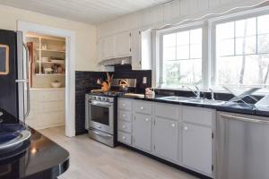 a kitchen with white cabinets and a stove top oven at Beautifully Renovated in Harwich Center in Harwich