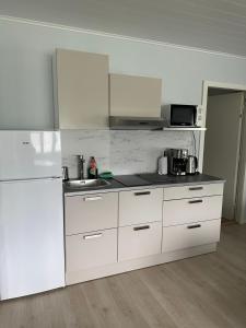 a white kitchen with a sink and a refrigerator at Iiris in Imatra