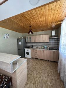 a kitchen with wooden cabinets and a refrigerator at Crystal Kazbegi in Kazbegi