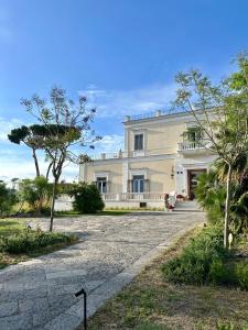 a large white house with a driveway in front of it at Villa De Cillis Carafa in Torre del Greco