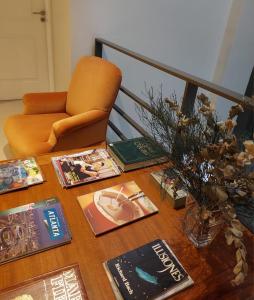 uma mesa com livros e revistas com uma cadeira em Rawson 3840 Alquiler de Suites La Lucila, Vicente Lopez, Buenos Aires em La Lucila