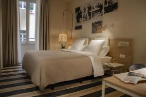 1 dormitorio con 1 cama grande con almohadas blancas en room Select Via Veneto en Roma