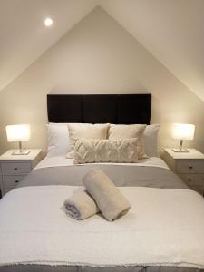 a bedroom with a large white bed with two lamps at The Cottage - Fairwinds in Doolin