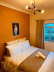 a bedroom with a large bed with orange walls at Lovely 3 bedroom in Siggiewi in Siġġiewi