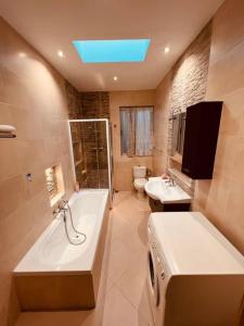 La salle de bains est pourvue d'une baignoire, de toilettes et d'un lavabo. dans l'établissement Lovely 3 bedroom in Siggiewi, à Siġġiewi