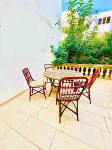 une table et des chaises assises sur une terrasse dans l'établissement Lovely 3 bedroom in Siggiewi, à Siġġiewi