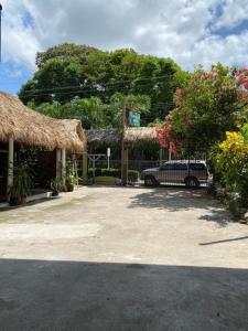a car parked in front of a house with a fence at Mauras Tropical Mini Hostel & Tours in Paquera