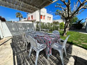 una mesa con sillas blancas y un mantel en el patio en VILLA GIORGIA, en Savelletri di Fasano