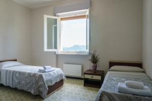 1 dormitorio con 2 camas y ventana en Albergo Payarin, en Ormea