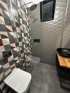 a bathroom with a shower with a toilet and a sink at Inn Hotel in Vlorë