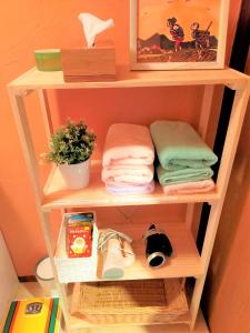 a wooden shelf with folded towels and a plant at Soma City - House - Vacation STAY 14664 