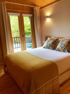 a bedroom with a bed and a large window at Tree Pool Villa in Arcos de Valdevez