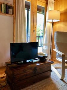 uma sala de estar com uma televisão de ecrã plano numa mesa de madeira em Tree Pool Villa em Arcos de Valdevez