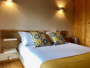 um quarto com uma cama branca com almofadas em Tree Pool Villa em Arcos de Valdevez