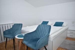 um quarto com uma cama com 2 cadeiras e uma mesa em Villa Rosa Rooms em Punat
