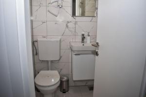 a bathroom with a toilet and a sink at Villa Rosa Rooms in Punat
