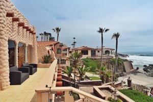 a house on the beach with palm trees and the ocean at Balcones Del Mar in Rosarito