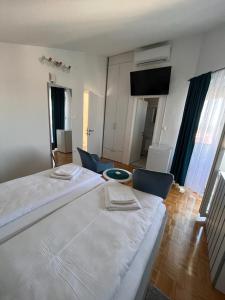 een slaapkamer met 2 bedden en een woonkamer bij Villa Rosa Rooms in Punat