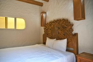 a bedroom with a bed with a wooden headboard at Balcones Del Mar in Rosarito