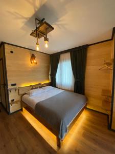um quarto com uma cama e uma parede de madeira em SoOnSuitApart em Çamlıhemşin