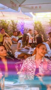 um grupo de pessoas sentadas em mesas em um restaurante em Vila Venus em Sânmartin