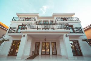 a white house with a balcony on top of it at Vila Venus in Sînmartin