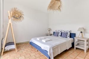 a bedroom with a bed with blue and white pillows at Villa Cavi Laurier in Le Grau-dʼAgde
