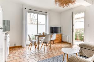a living room with a table and chairs at Villa Cavi Laurier in Le Grau-dʼAgde