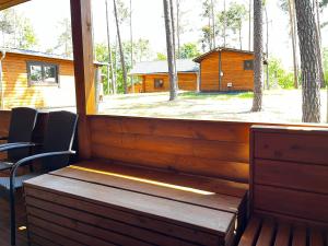 een veranda met een bank en uitzicht op een hut bij Domek Dębowy 2 in Lubniewice +20 foto's