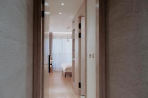 un couloir menant à une chambre avec un lit dans l'établissement 伊莉莎白甜夜, à Magong