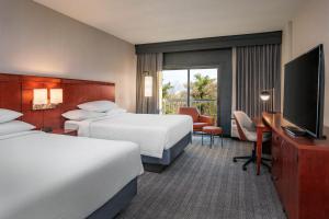 a hotel room with two beds and a flat screen tv at Courtyard by Marriott Boston Andover in Andover