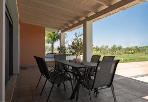 een tafel en stoelen op een patio met uitzicht bij Villa Manolia in Preveza