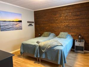 a bedroom with two beds and a wooden wall at Vemdalsskalet huset Myltan in Vemdalen