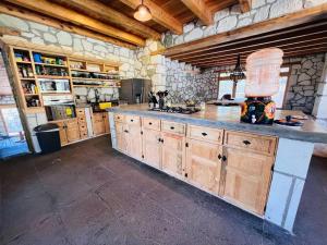 een grote keuken met houten kasten en een stenen muur bij Finca Bermúdez - Casa Francisca in Huasca de Ocampo