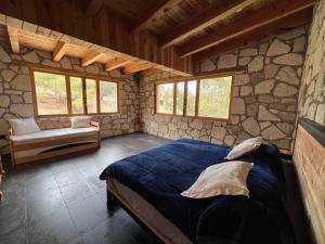 een slaapkamer met een blauw bed in een stenen muur bij Finca Bermúdez - Casa Francisca in Huasca de Ocampo