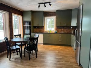 a kitchen with a table and chairs and a refrigerator at Vemdalsskalet huset Myltan in Vemdalen