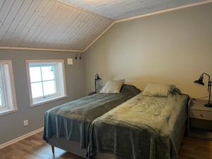 a bedroom with a bed and two windows at Vemdalsskalet huset Myltan in Vemdalen