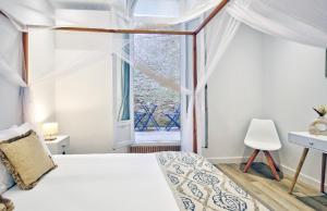 a bedroom with a white bed and a window at Charmant appartement avec extérieur privatif in Sète