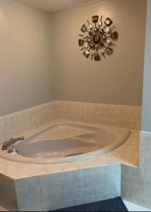 a large tub in a bathroom with a clock on the wall at Florida Oasis in Auburndale
