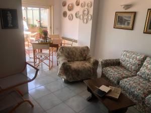 un soggiorno con un divano, una sedia e un tavolo di Mare Luna Casa a Taormina