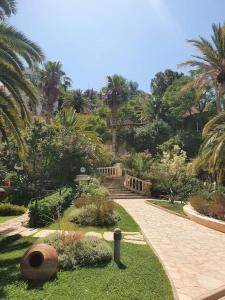 a garden with a walkway and some plants and trees at Cactus Garden Kalkan - Private Mediterranean Home at Club Patara in Kalkan